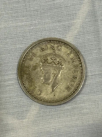 George VI portrait on obverse; floral wreath with “ONE RUPEE INDIA 1945” on reverse