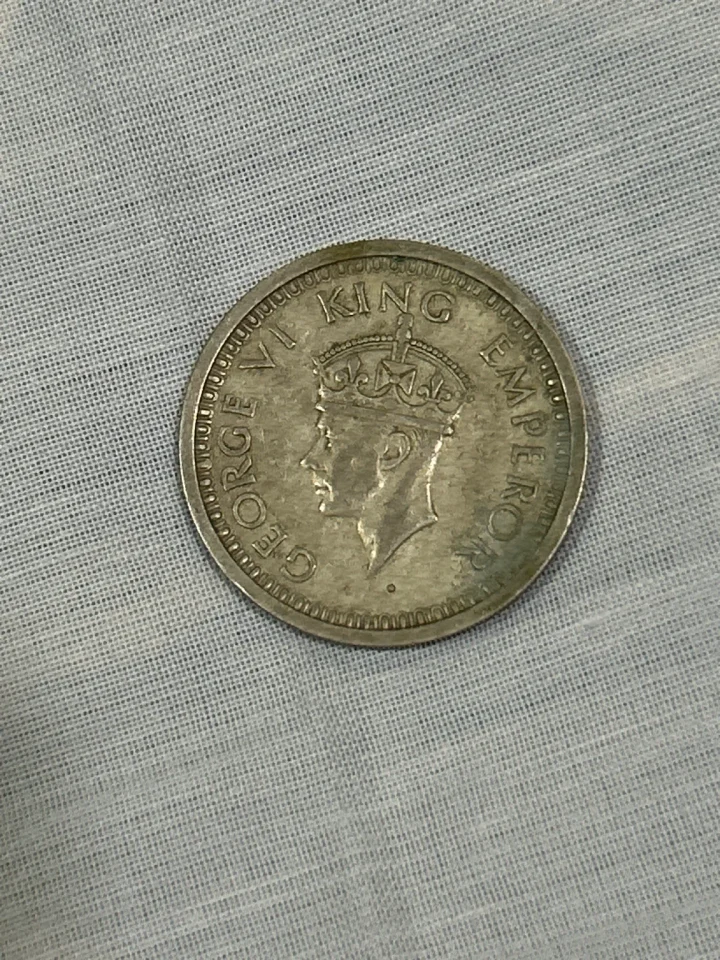 George VI portrait on obverse; floral wreath with “ONE RUPEE INDIA 1945” on reverse. — coin, photo 1 of 2