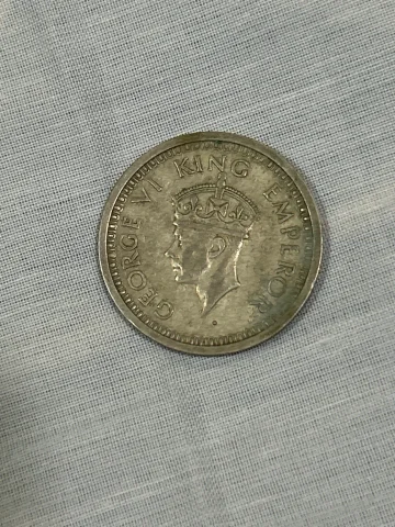 George VI portrait on obverse; floral wreath with “ONE RUPEE INDIA 1945” on reverse.