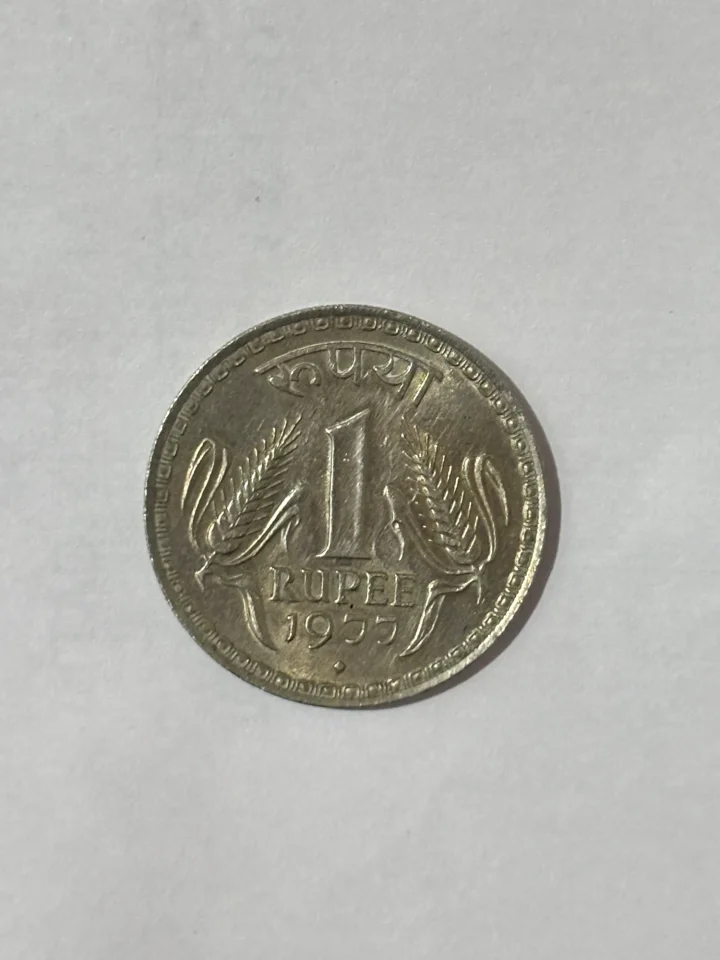 Indian 1 Rupee coin featuring the iconic two ears of corn design.
